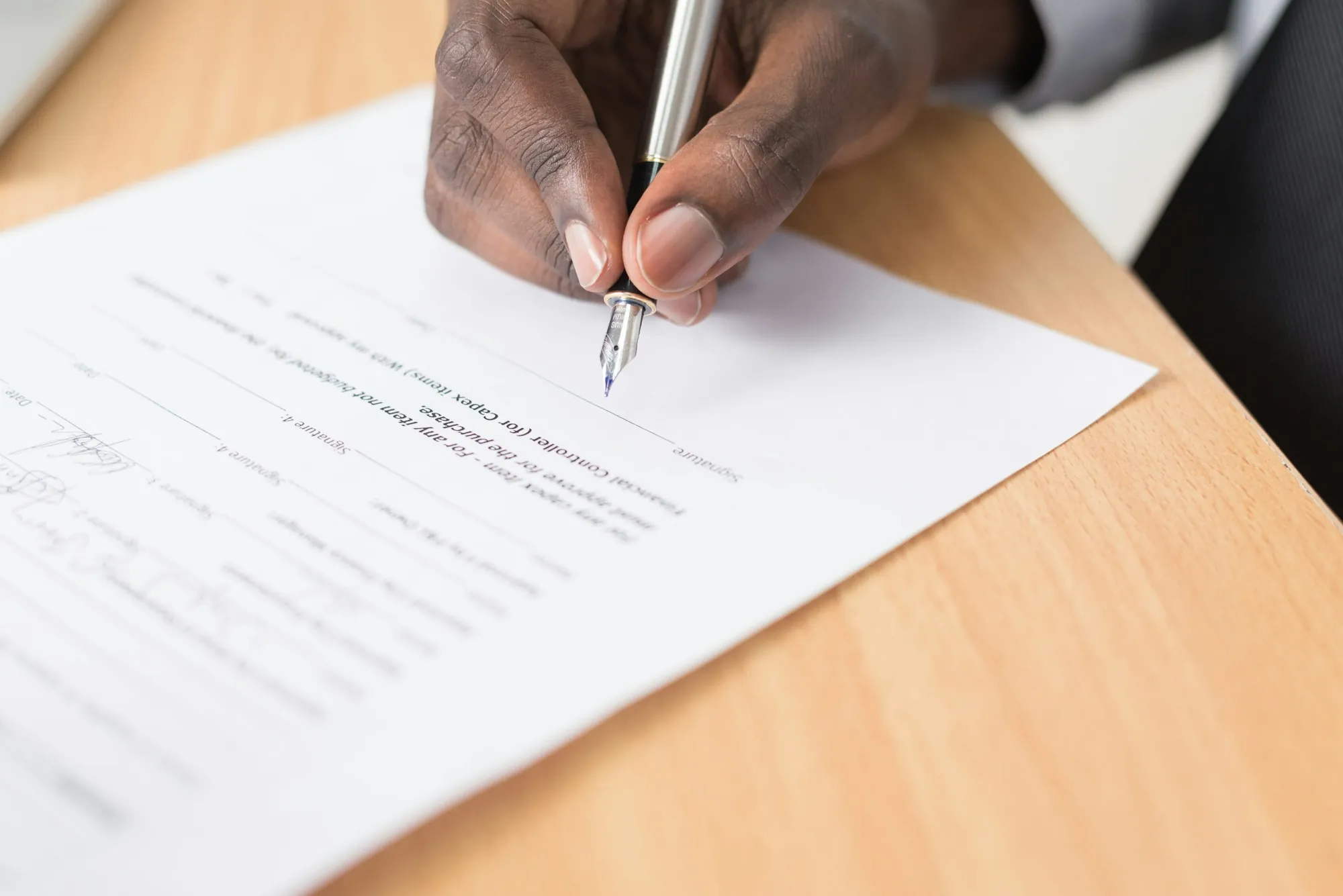 Hand writing on a sheet of paper on a wooden desk, like a homeowner going through the detach and reset line item on an Orland Hills insurance roof estimate
