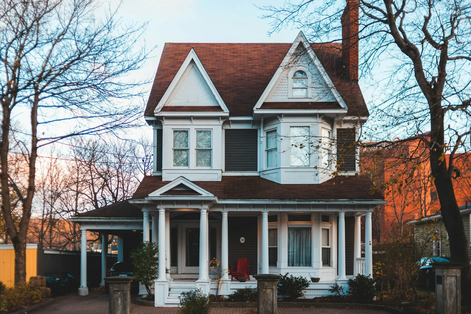 Two-story Victorian house with a brown roof and white porch